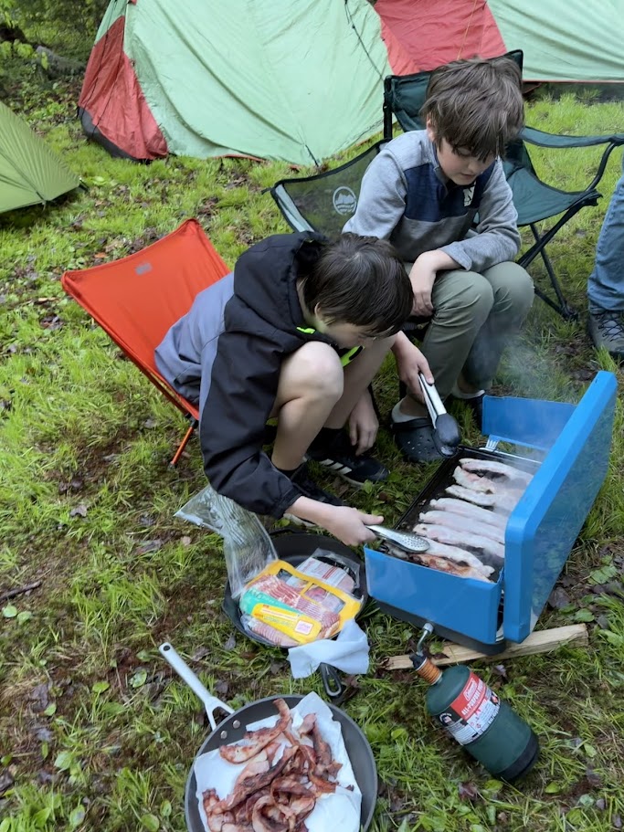 Scout preparing food at the Semiquincentennial Camporee.